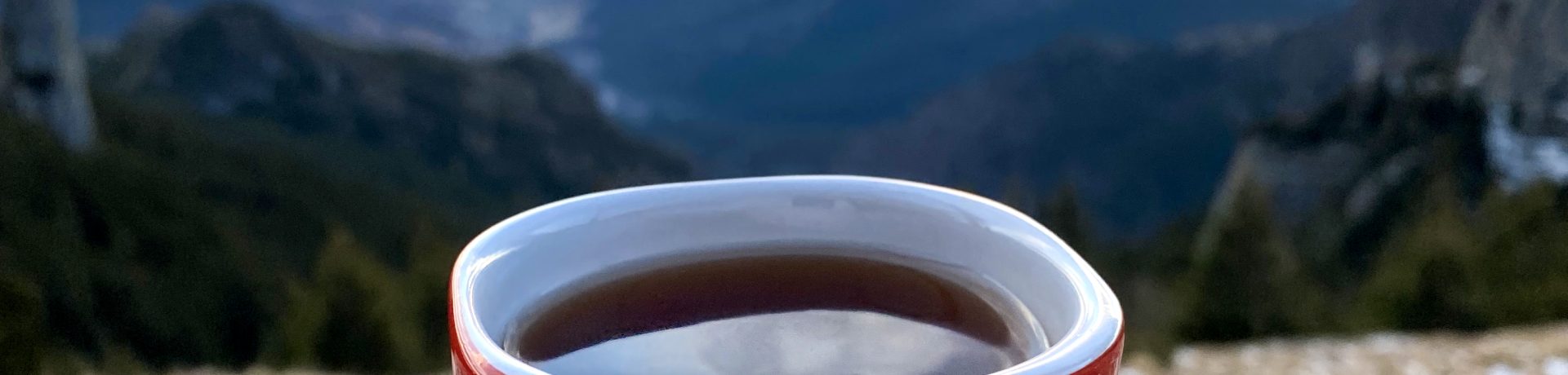A cup of coffee on the Toaca peak in the Carpathians at sunset, Romania